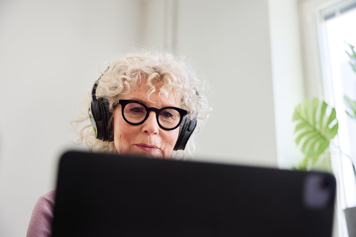 En kvinne med hodetelefoner i en samtale på skjerm