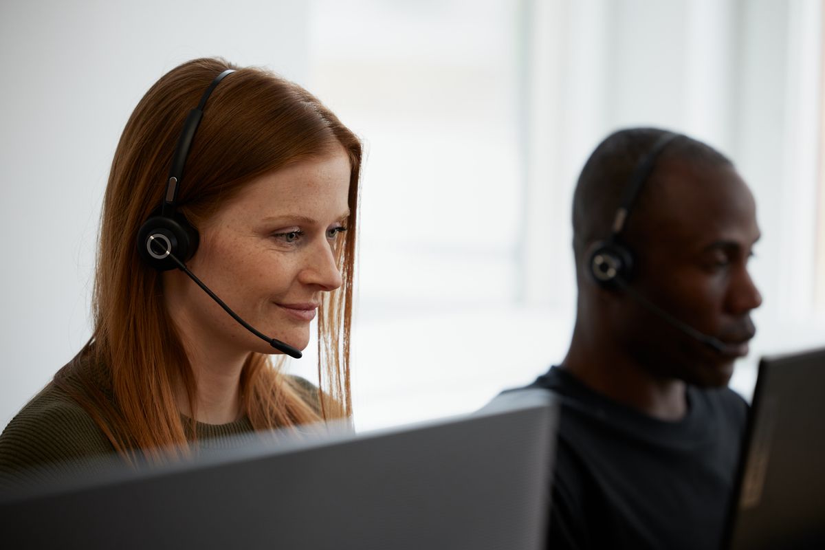 Ansatte med headset ved skjermen